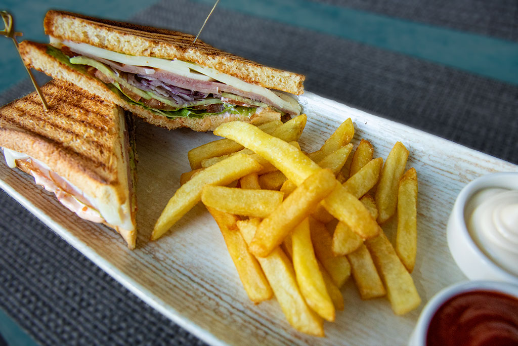 Club sandwich with ham and french fries